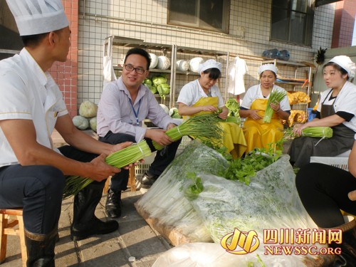 校长杨会平(左二)深入厨房,检查饮食卫生管理制度的执行情况