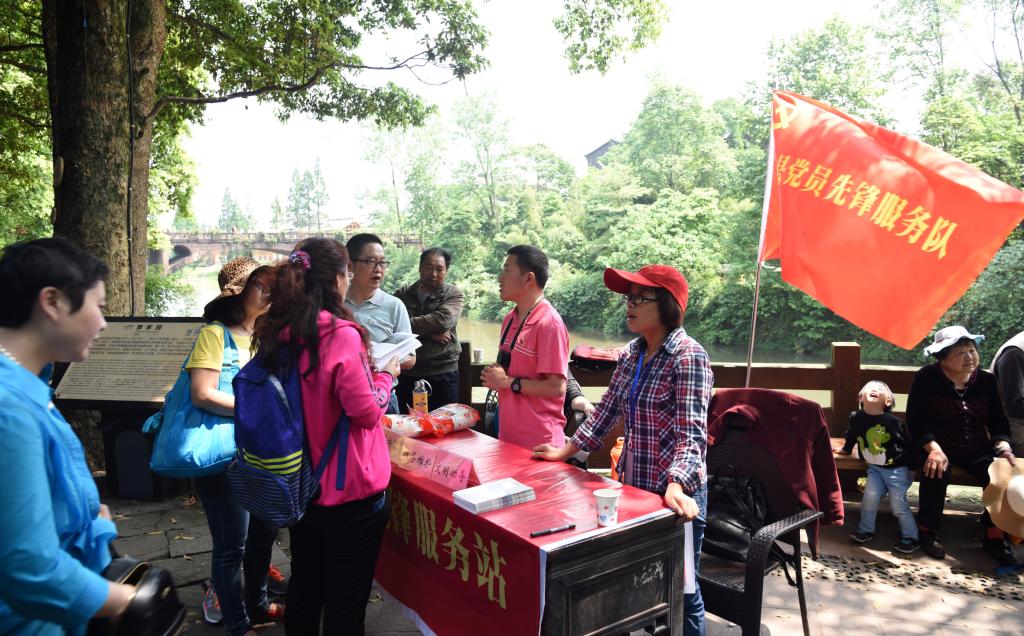 5月1日,在柳江古镇曾家园门外,党员先锋服务队员王政等热情地解答游客的问询