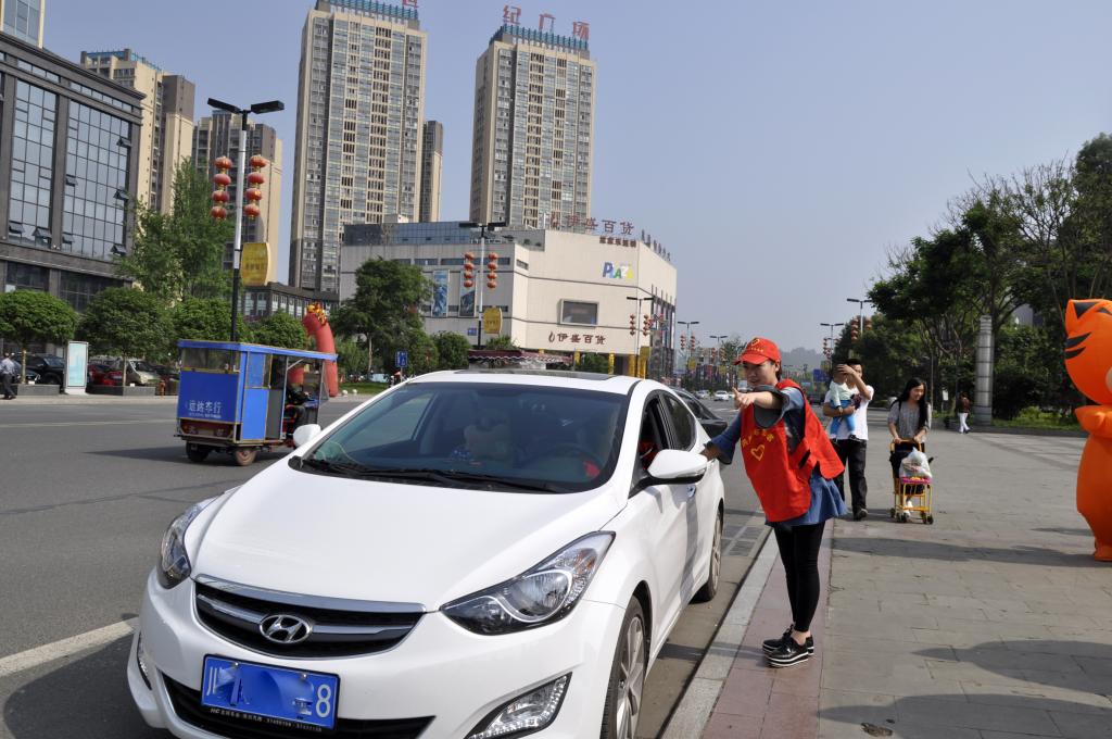 5月1日,在洪雅广场服务点,志愿者为自驾游客人指路