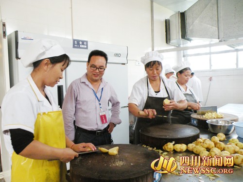 校长杨会平(左二)深入厨房,检查饮食卫生管理制度的执行情况